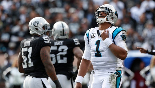 Carolina Panthers quarterback Cam Newton (1) reacts after taking a hit against the Oakland Raiders in the first quarter at Oakland Coliseum.