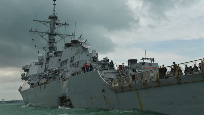 A general view shows the port side of the United States Navy missile destroyer USS John S McCain and a hole in its hull as it is towed into the Changi Navy Base off the eastern coast of Singapore, Aug. 21,2017. Ten sailors are missing and five were injured after the guided-missile destroyer collided with the Liberian-flagged oil tanker Alnic MC off the coast between Singapore and Malaysia.