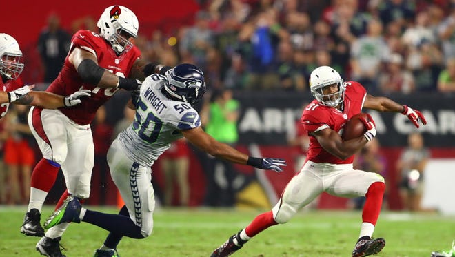 Cardinals running back David Johnson (31) is chased by Seahawks linebacker K.J. Wright (50) in the first half.