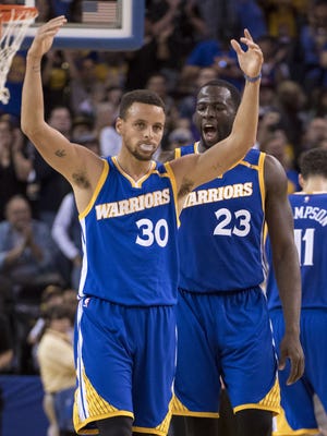 Golden State Warriors guard Stephen Curry (30) and forward Draymond Green celebrate against the Phoenix Suns during the fourth quarter at Oracle Arena.