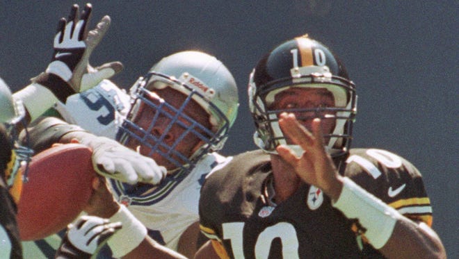 Seattle Seahawks defensive tackle Cortez Kennedy knocks the ball out of the hand of Pittsburgh Steelers quarterback Kordell Stewart in 1999.