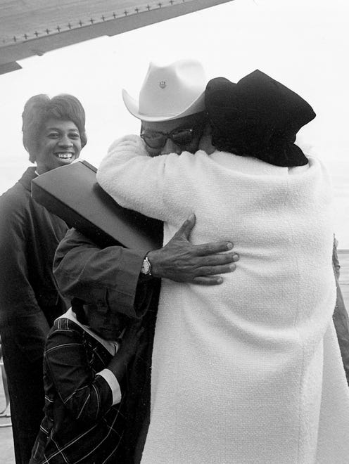 Tennessee A&I State University (now known as TSU) track coach Ed Temple, center, is greeted by his wife, Charlie B., after he walked off the plane after arriving from the Tokyo Olympics at Nashville Municipal Airport on Oct. 28, 1964. Olympic gold medalist Edith McGurie, left, looks on.