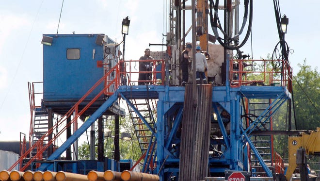 In this June 25, 2012, file photo, a crew works on a gas drilling rig at a well site for shale-based natural gas in Zelienople, Pa.