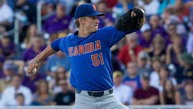 Florida Gators pitcher Brady Singer (51) throws against the LSU Tigers in the first inning in game one of the championship series of the 2017 College World Series at TD Ameritrade Park Omaha.