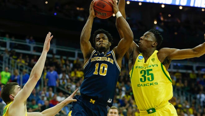 Michigan Wolverines guard Derrick Walton Jr. (10) controls the ball as Oregon Ducks guard Payton Pritchard (3) and forward Kavell Bigby-Williams (35) guards during the first half in the semifinals of the midwest Regional of the 2017 NCAA Tournament at Sprint Center.