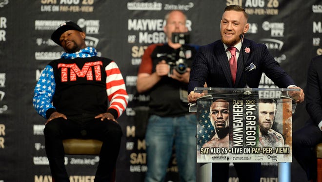 Conor McGregor speaks as Floyd Mayweather reacts during a world tour press conference to promote the upcoming Mayweather vs McGregor boxing match.