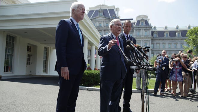 McConnell speaks to members of the media alongside fellow Senate GOP leaders John Cornyn and John Thune outside the West Wing of the White House after a lunch meeting with President Trump on July 19, 2017.