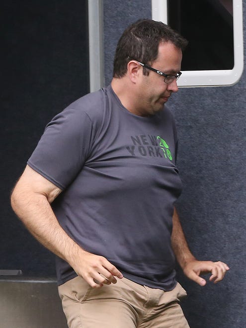 Subway restaurant spokesman Jared Fogle leaves a police vehicle outside his home as a Federal authority holds the door, Tuesday, July 7, 2015, in Zionsville. FBI agents and Indiana State Police have removed electronics from the property.