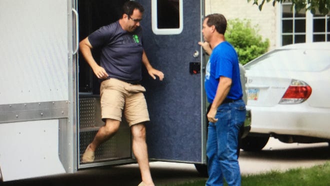 Jared Fogle, left, who rose to fame as the Subway pitchman, steps from a police evidence truck parked in the driveway of his Zionsville, Ind., home on Tuesday, July 7, 2015.