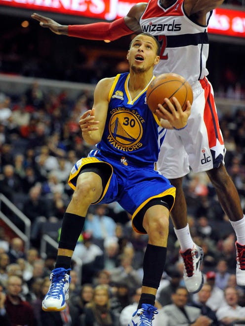 2012: Golden State Warriors point guard Stephen Curry shoots a layup against Washington Wizards guard John Wall.