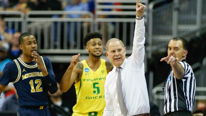 Michigan Wolverines head coach John Beilein reacts as Michigan Wolverines guard Muhammad-Ali Abdur-Rahkman (12) and Oregon Ducks guard Tyler Dorsey (5) look on during the first half in the semifinals of the midwest Regional of the 2017 NCAA tournament at Sprint Center.