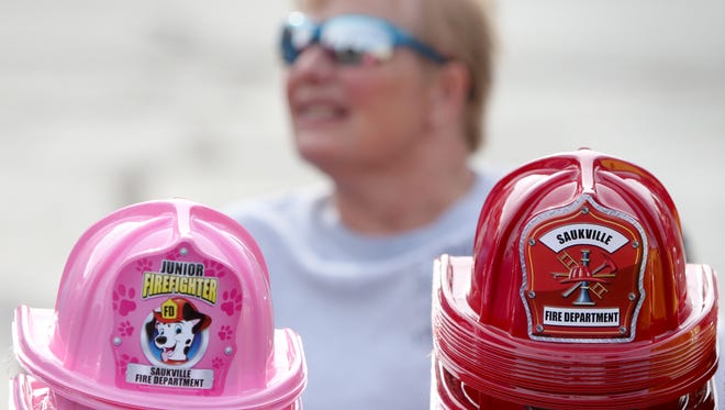 Avis Gillson, Fire Prevention officer for the Saukville Fire Department, has children's fire helmets at the ready during Saukville's National Night Out at Grady Park on Aug. 15.