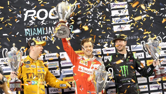 Sebastian Vettel celebrates his victory after winning the Nations Cup, next to Kyle Bush (left) and Kurt Bush, from Team USA NASCAR.