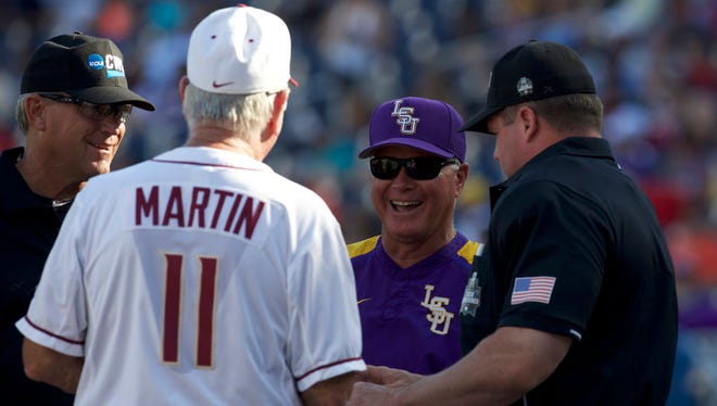 Florida State Seminoles head coach Mike Martin (11) and LSU Tigers head coach Paul Mainieri (C) meet with the umpires prior to their game at TD Ameritrade Park Omaha.