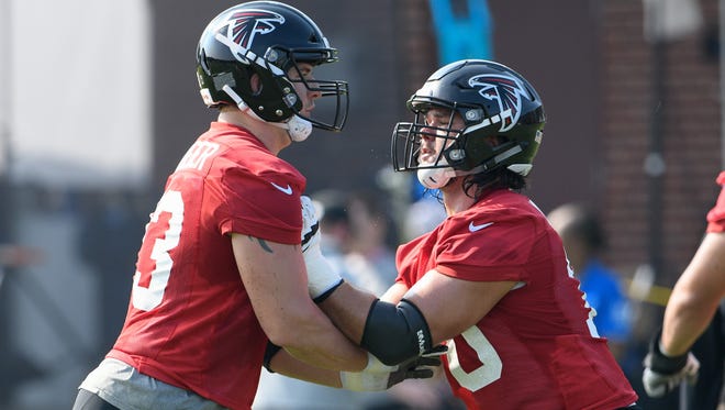 Atlanta Falcons offensive tackle Ryan Schrader (73) and tackle Jake Matthews (70) work on a blocking drill on the field during training camp at the Falcons Training Complex.