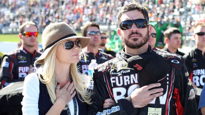 Martin Truex Jr. and his girlfriend Sherry Pollex stand during the national anthem before the Sprint Cup Series race at Martinsville Speedway on Oct. 26, 2014.
