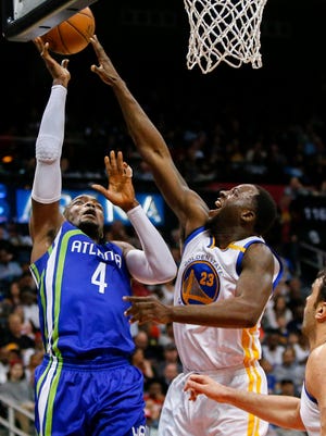 Atlanta Hawks forward Paul Millsap (4) shoots the ball over Golden State Warriors forward Draymond Green (23) go up for a rebound in the third quarter at Philips Arena.