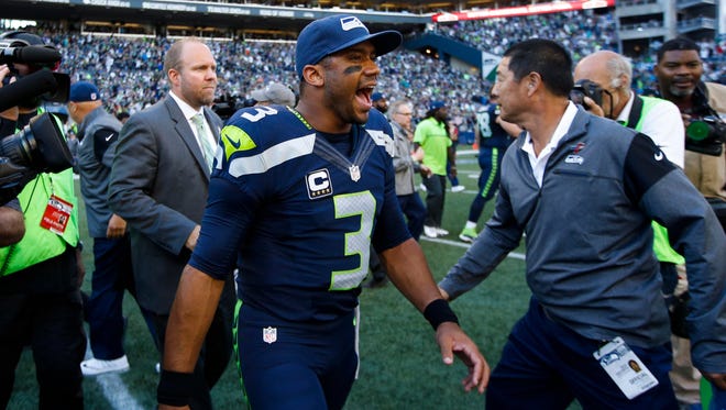 Seattle Seahawks quarterback Russell Wilson (3) walks to midfield to shake hands with members of the Miami Dolphins following a 12-10 Seattle victory at CenturyLink Field.