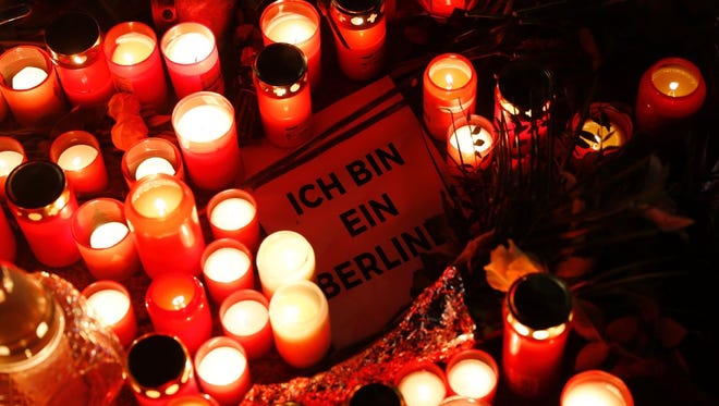 A sign quoting John F. Kennedy's sentence 'I am a Berliner' sits amid candles at a makeshift memorial for those killed in Monday's attack in Berlin.