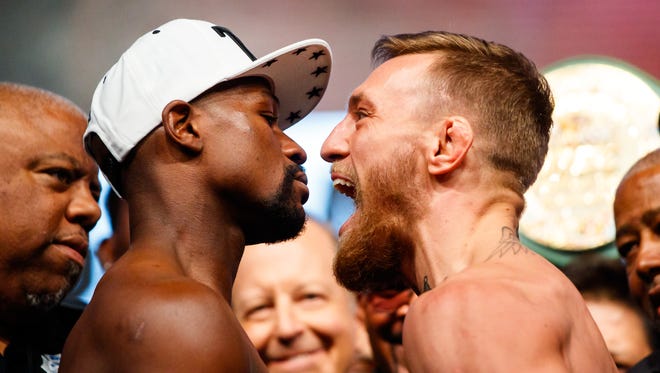 Conor McGregor (right) screams in the face of Floyd Mayweather during weigh-ins for their boxing match at T-Mobile Arena.