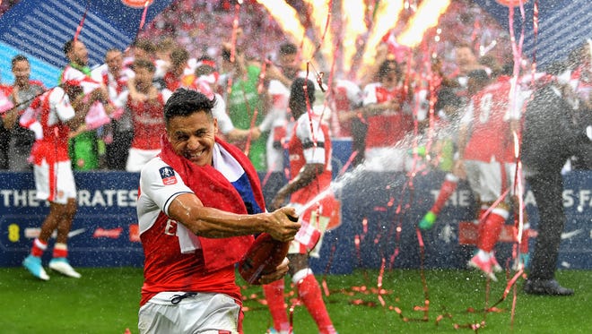 Arsenal's Alexis Sanchez sprays champagne in celebration.