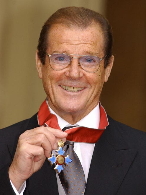 Sir Roger Moore, shows his knighthood at Buckingham Palace in London Oct. 9, 2003. Moore received his knighthood from the Queen for his tireless charity work.