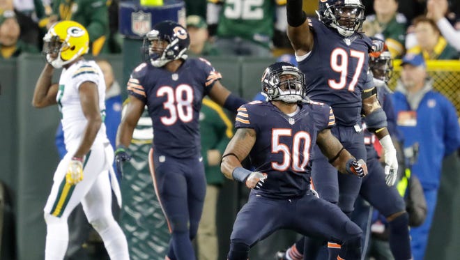 Chicago Bears inside linebacker Jerrell Freeman (50) and outside linebacker Willie Young (97) celebrate a goal line stand on fourth down during the first quarter against the Green Bay Packers at Lambeau Field.