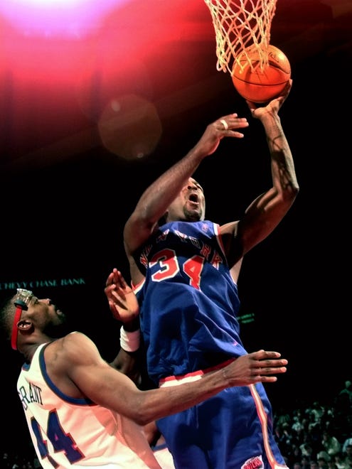 Charles Oakley (34) goes to the basket against Harvey Grant (44).