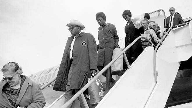 Tennessee A&I State University (now known as TSU) coach Ed Temple, center, and Tigerbelles sprinters Wyomia Tyus and Edith McGuire walk off the plane after arriving from Tokyo at the Nashville Municipal Airport on Oct. 28, 1964. In the Olympic games in Tokyo, McGure won the gold in the 200-meters and Tyus picked up gold in the 100-meter dash.