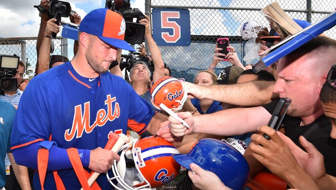 Sept. 19: Tim Tebow signs autographs for fans after his workout.