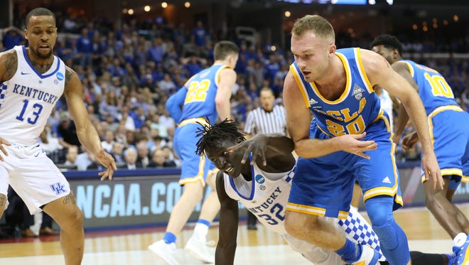 Kentucky forward Wenyen Gabriel (32) and UCLA guard Bryce Alford chase a loose ball as Kentucky guard Isaiah Briscoe (13) looks on during the first half of their game in the Sweet 16 of the NCAA tournament at FedExForum in Memphis.