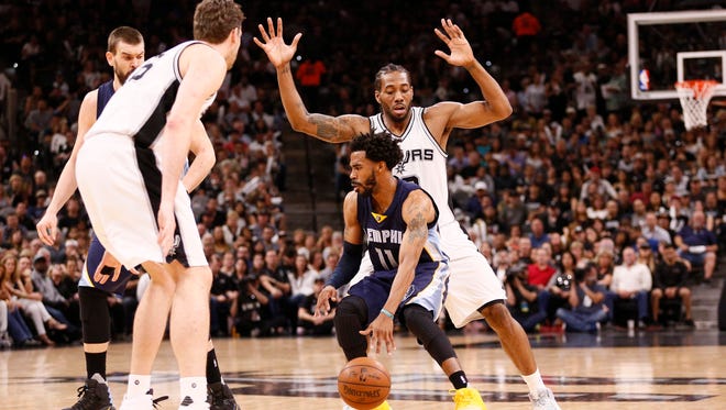 Memphis Grizzlies point guard Mike Conley (11) dribbles the ball as San Antonio Spurs small forward Kawhi Leonard (behind) defends during the first half in game five of the first round of the 2017 NBA Playoffs at AT&T Center.