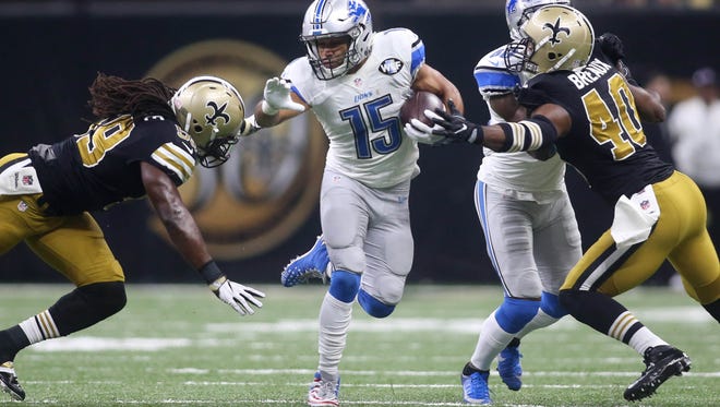 Detroit Lions wide receiver Golden Tate (15) carries the ball between New Orleans Saints cornerback Delvin Breaux (40) and outside linebacker Dannell Ellerbe (59) during the first quarter at Mercedes-Benz Superdome.