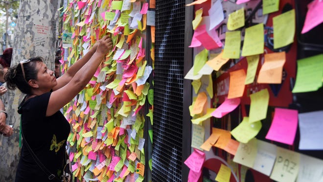 People leave post-it notes with messages against the attacks and in tribute to the victims of the Barcelona attack, on a kiosk on Las Ramblas boulevard in Barcelona on Aug. 19, 2017.