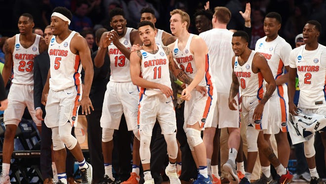 The Florida Gators celebrate with guard Chris Chiozza (11) after he hit The Shot to beat Wisconsin.