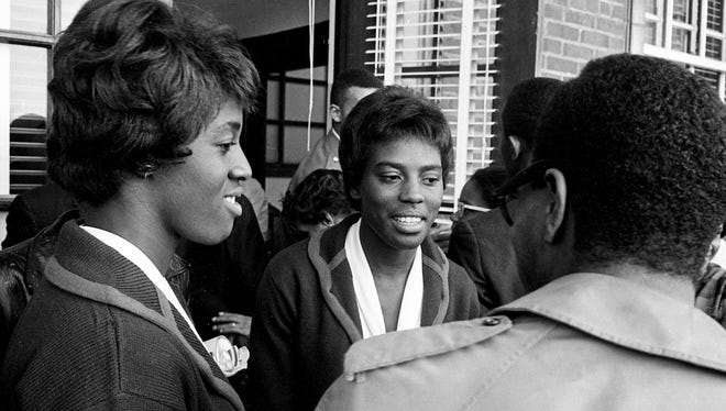 Tigerbelles sprinters Edith McGuire, left, and Wyomia Tyus greet a supporter during a welcome home celebrate on the campus of Tennessee A&I State University Oct. 28, 1964.