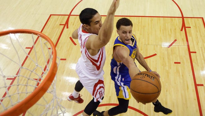 2015: Stephen Curry shoots as Houston Rockets guard Nick Johnson defends.