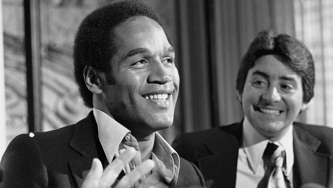 Simpson in 1978 next to San Francisco 49ers owner Edward DeBartolo Jr. at a news conference announcing the team's acquisition of Simpson.