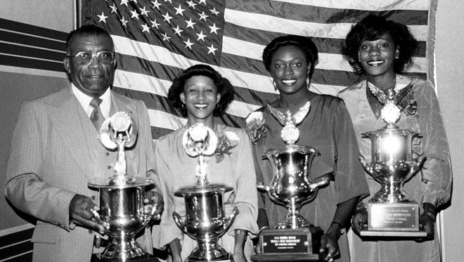 Tigerbelles coach Ed Temple, left, post-graduate Debby Jones and seniors Chandra Cheeseborough and Ernestine Davis holds four of the school's National Indoor track and field championship trophies at their annual banquet at the Airport Hilton Oct. 5, 1981.