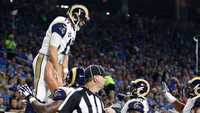 Los Angeles Rams quarterback Case Keenum (17) celebrates with teammates after scoring a rushing touchdown during the second quarter against the Detroit Lions at Ford Field.