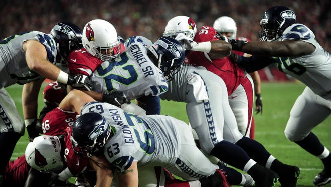 Seahawks running back Christine Michael (32) is tackled by the Cardinals on the goal line during the first half.