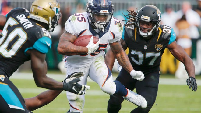 Jacksonville Jaguars outside linebacker Telvin Smith (50) and strong safety Johnathan Cyprien (37) chase Denver Broncos running back Kapri Bibbs (35) during the second quarter  of an NFL football game at EverBank Field.