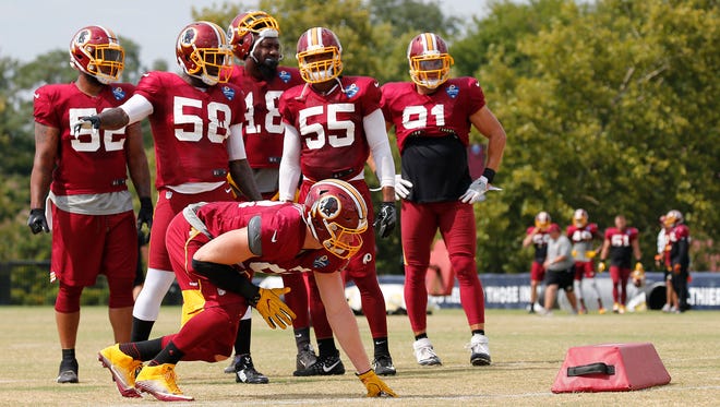 Washington Redskins linebacker Trent Murphy prepares to run a drill as other linebackers look on during NFL training camp, Thursday, Aug. 3, 2017 in Richmond, Va.