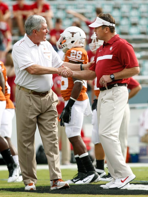Oklahoma coach Bob Stoops shakes hands with Texas coach Mack Brown before their game at the Cotton Bowl in 2011.