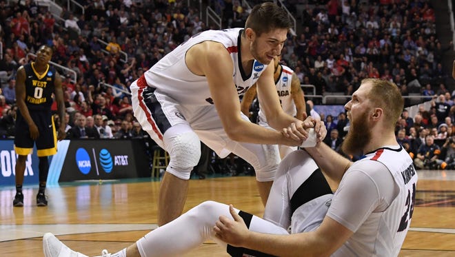Gonzaga Bulldogs center Przemek Karnowski (24) celebrates as he is helped up by forward Zach Collins (32) during the second half in the semifinals of the West Regional of the 2017 NCAA Tournament against the West Virginia Mountaineers at SAP Center.