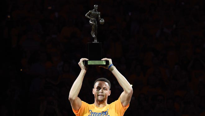 2016: Curry hoists the MVP trophy before Game 5 of the second round of the playoffs.