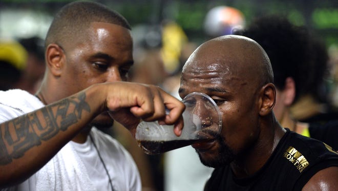 Floyd Mayweather Jr. sips a beverage during a media workout in preparation for his fight against Conor McGregor at Mayweather Boxing Club.