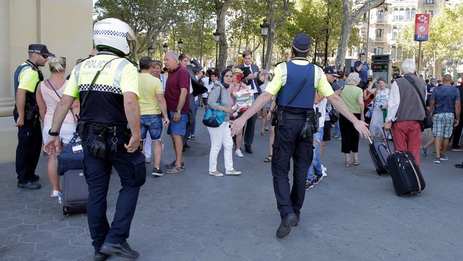 Police officers tell members of the public to leave the scene on a street in Barcelona, Spain on Aug. 17, 2017.