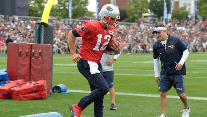 New England Patriots quarterback Tom Brady (12) runs through a drill during training camp at Gillette Stadium.