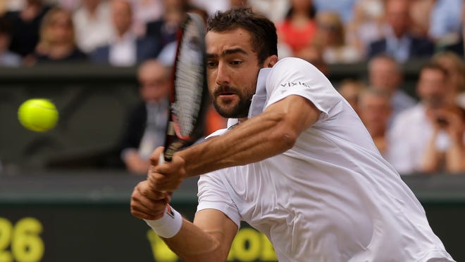 Marin Cilic returns to Roger Federer during their singles match.